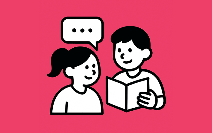 Dos estudiantes conversan mientras leen un libro, simbolizando la comunicación, el lenguaje y el aprendizaje de idiomas.