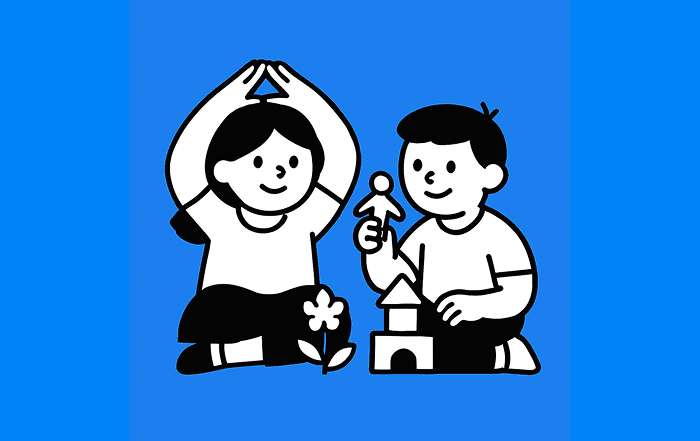 Dos niños construyen juntos un edificio con bloques; el niño sostiene una figura humana, representando la creación de entornos de aprendizaje y desarrollo.